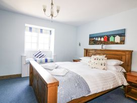 A bedroom with a bed and window at Squirrels Dray, Gorran Haven