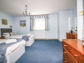 A bedroom with two beds and a chest of drawers at Squirrels Dray in Gorran Haven