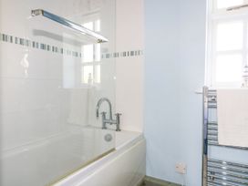 A bathroom with a bathtub and towel radiator at Squirrels Dray in Gorran Haven