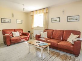 A living room with a sofa and coffee table at Foxes Den in Gorran Haven