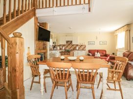 A kitchen with dining table and chairs at Foxes Den in Gorran Haven