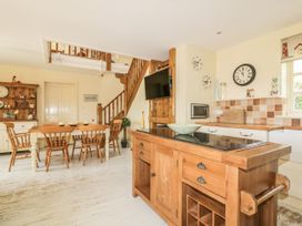 A kitchen with a dining area and staircase at Foxes Den in Gorran Haven