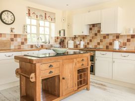 A kitchen with a wooden island and sink at Foxes Den in Gorran Haven