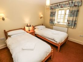 A bedroom with twin beds and a window at Foxes Den in Gorran Haven