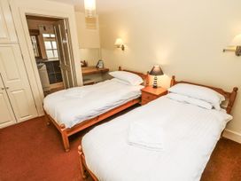 A bedroom with twin beds and a nightstand at Foxes Den in Gorran Haven