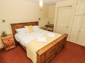 A bedroom with a bed and nightstand at Foxes Den in Gorran Haven