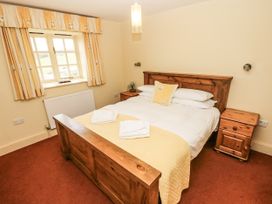 A bedroom with a bed and nightstand at Foxes Den in Gorran Haven