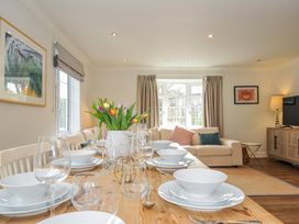 A dining room with a table set and a sofa at Samphire in Rock