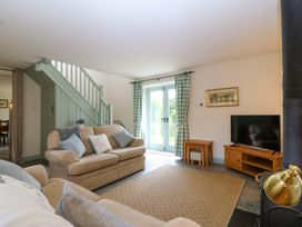 A living room with a sofa and television at No 2 The Stables Capel Coch near Llannerch-Y-Medd