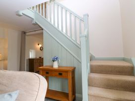 A staircase with a console table and flower vase at No 2 The Stables Capel Coch near Llannerch-Y-Medd