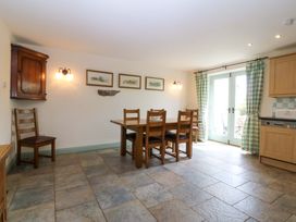 A dining room with a table and chairs at No 2 The Stables Capel Coch near Llannerch-Y-Medd