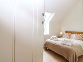 A bedroom with a bed and towels at No 2 The Stables Capel Coch near Llannerch-Y-Medd