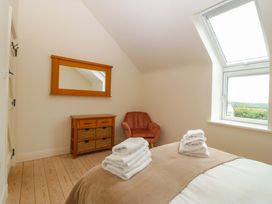 A bedroom with towels on bed and a mirror on the wall at No 2 The Stables Capel Coch near Llannerch-Y-Medd
