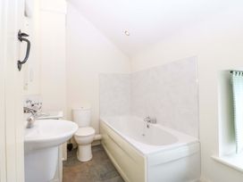 A bathroom with a bathtub, sink, and toilet at No 2 The Stables in Capel Coch near Llannerch-Y-Medd