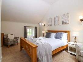 A bedroom with a wooden bed and side table at No 2 The Stables Capel Coch near Llannerch-Y-Medd