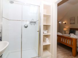 A bathroom with a shower and shelves at No 2 The Stables near Capel Coch near Llannerch-Y-Medd