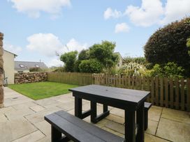 A garden with a table and benches at No 2 The Stables Capel Coch near Llannerch-Y-Medd