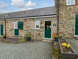 An outdoor view of a stone cottage with green doors at No 3 The Dairy Capel Coch near Llannerch-Y-Medd