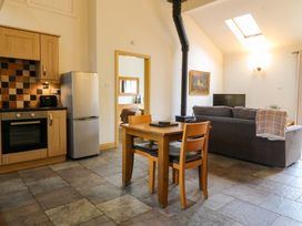 A kitchen and living area with appliances and furniture at No 3 The Dairy Capel Coch near Llannerch-Y-Medd