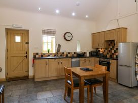 A kitchen with a table and chairs at No 3 The Dairy Capel Coch near Llannerch-Y-Medd