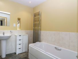 A bathroom with a bathtub and sink at No 3 The Dairy Capel Coch near Llannerch-Y-Medd