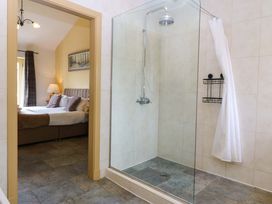 A bathroom with a shower and a view of a bedroom at No 3 The Dairy Capel Coch near Llannerch-Y-Medd