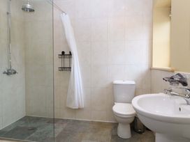 A bathroom with a shower, toilet, and sink at No 3 The Dairy Capel Coch near Llannerch-Y-Medd