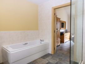 A bathroom with a bathtub and shower at No 3 The Dairy, Capel Coch near Llannerch-Y-Medd