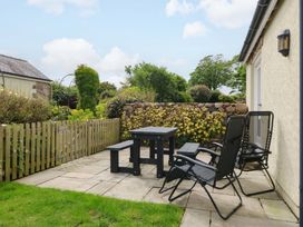 A garden area with a table and chairs at No 3 The Dairy Capel Coch near Llannerch-Y-Medd