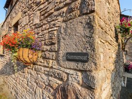 A flower basket and nameplate on a stone wall at Summerseat in Kirkby Stephen
