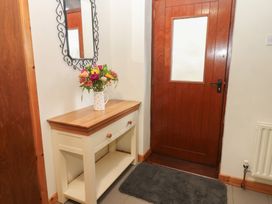 A hallway with a table and flowers at Summerseat in Kirkby Stephen