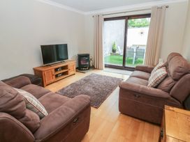 A living room with a television and sofa at Summerseat in Kirkby Stephen