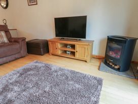 A living room with a television and fireplace at Summerseat in Kirkby Stephen