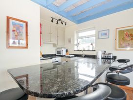 A kitchen with a countertop and bar stools at Beachside in Polzeath
