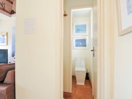 A bathroom with a white toilet and framed pictures at Beachside in Polzeath