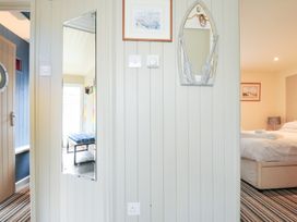A bedroom with a mirror and a picture at Beachside in Polzeath