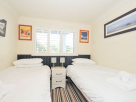 A bedroom with twin beds and a bedside table at Beachside Polzeath
