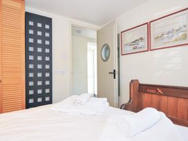 A bedroom with a bed and towels at Beachside in Polzeath