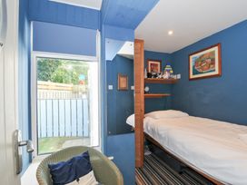 A bedroom with a bed and bookshelf at Beachside in Polzeath