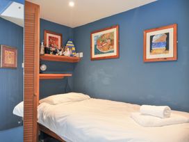 A bedroom with a bed and artwork at Beachside in Polzeath