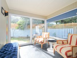 A conservatory with chairs and a table at Beachside in Polzeath