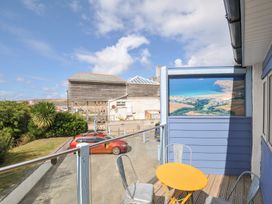 A deck with a yellow table and chairs overlooking a landscape at Beachside in Polzeath