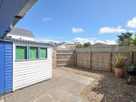 A garden with a shed and patio area at Beachside in Polzeath
