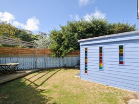 A garden with a shed and seating area at Beachside in Polzeath