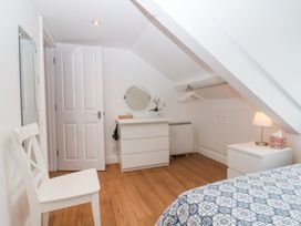 A bedroom with a bed and a mirror at Smugglers Loft in Looe