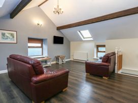 A living room with sofas and a coffee table at Llofft Yr Yd in Porthmadog