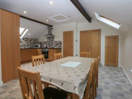 A kitchen with a dining table and chairs at Llofft Yr Yd Porthmadog