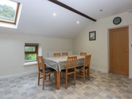 A dining room with a table and chairs at Llofft Yr Yd in Porthmadog