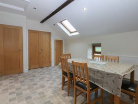 A dining room with a table and chairs at Llofft Yr Yd in Porthmadog