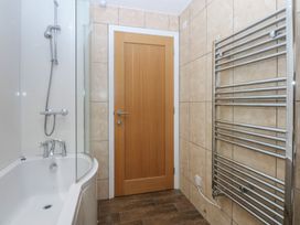 A bathroom with a bathtub and shower at Llofft Yr Yd in Porthmadog